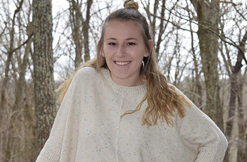 A young woman posing in the woods.